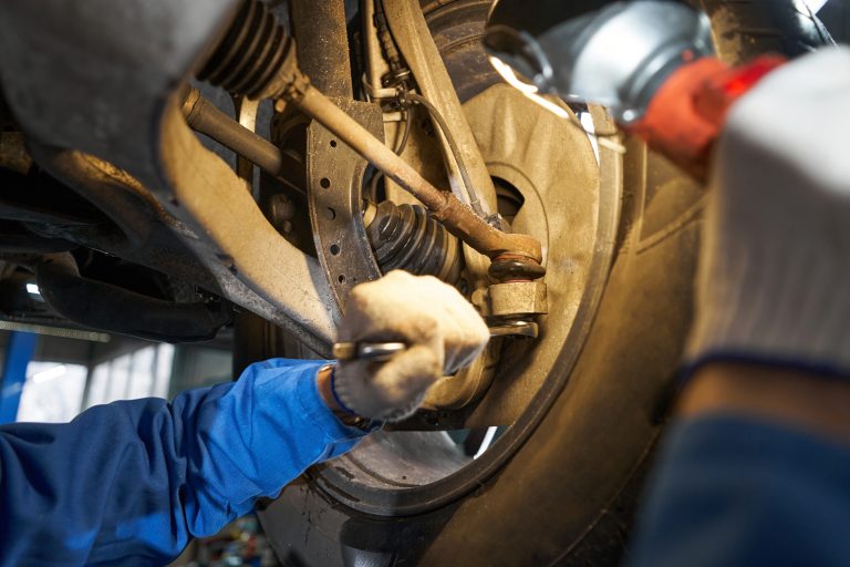 Man is performing technical inspection of car